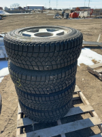 Stack of four tires on aluminum rims