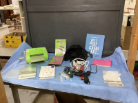 BOX W/ CRAFTING ITEMS - CUTTLEBUG MACHINE, GLUE GUNS & GLUE, NOTEPADS, ARTBOOK