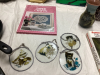 (3) SMALL BOXES OF HOUSEHOLD ITEMS - CAT BOOKS, DECOR, CAST FRYPAN CLOCK, NEEDLEPOINT PICTURE, "THE ROCK" FRY PANS - 3