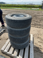 Stack of four Michelin tires on steel rims