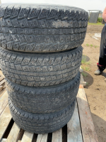 Stack of four truck tires on rims