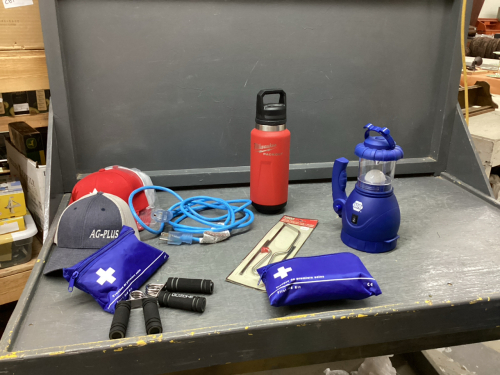 BOX OF HATS, MILWAUKEE THERMOS, DUAL LIGHT WORK LIGHT/FLASHLIGHT, EXTENSION CORD