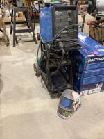 MILLER WELDER ON METAL CART, HELMET, GLOVES, ARGON CO2 BOTTLE W/ REGULATORS