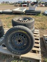 Stack of four light tires on rims