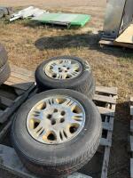 Stack of four car tires on rims