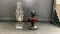 (2) KEROSENE LAMPS - ONE W/ RED GLASS/METAL BASE, ONE W/ CLEAR GLASS