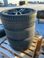 Stack of four tires on black aluminum Ford rims
