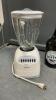 BOX OF KITCHEN ITEMS - OSTERIZER BLENDER, STEAM IRON, HIGHBALL GLASSES & DECANTER, SILICONE & PLASTIC BAKING TOOL SET - 3