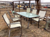 Glass top patio table with 6 arm chairs