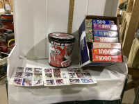 BOX OF PUZZELS & HOCKEY TIN WITH SOME HOCKEY CARDS