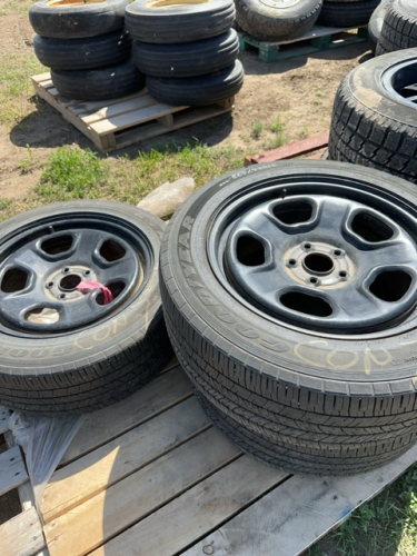 Three Goodyear car tires on five bolt Ford steel rims