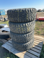 Stack of four truck tires on Chev rims