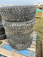 Pallet of four truck tires on rims