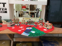 CHRISTMAS VILLAGE - (6) BUILDINGS, A FEW ACCESSORIES - IN A GOOD LIDDED TOTE AND A TREE SKIRT